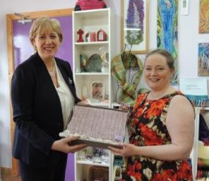 Liz presenting Minister Humphries with a handwoven 'Renaissance' wrap, inspired by County Monaghan's lace-making traditions
